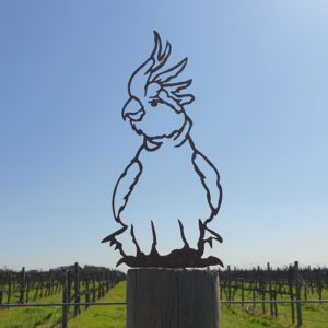 A beautiful Cockatoo Post Topper made from rusted metal, featuring a laser-cut design that enhances garden posts or fences.