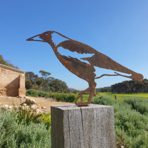 A rusted metal Magpie Post Topper crafted from Corten steel, set on a garden post, embodying the spirit of Australian wildlife and rustic charm.