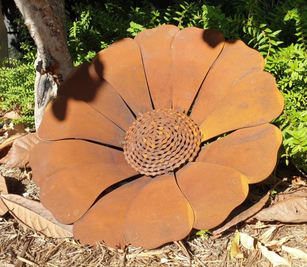 A vibrant Sun Flower With Chain Centre sculpture in a garden, showcasing its beautiful orange-red hues and unique chain centre design.