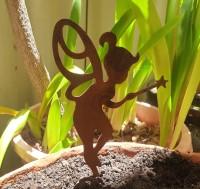 A pair of rusted metal fairy sculptures standing on feet spikes, made from 1.6mm thick Corten steel. Suitable for garden beds or pots. Dimensions: 28cm x 14cm.