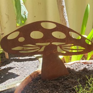 A rusted metal Mushroom Wide garden sculpture made from 1.6mm Corten steel, measuring 30cm x 27cm, including its attached spike. It adds a rustic, fairy-tale charm to garden beds or pots, with a natural orange-red patina.