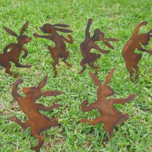 A delightful set of six Dancing Bunnies made from Corten steel, each 25-27 cm tall, adding charm to garden beds and pots with a natural rust finish.