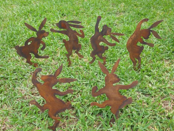 A delightful set of six Dancing Bunnies made from Corten steel, each 25-27 cm tall, adding charm to garden beds and pots with a natural rust finish.