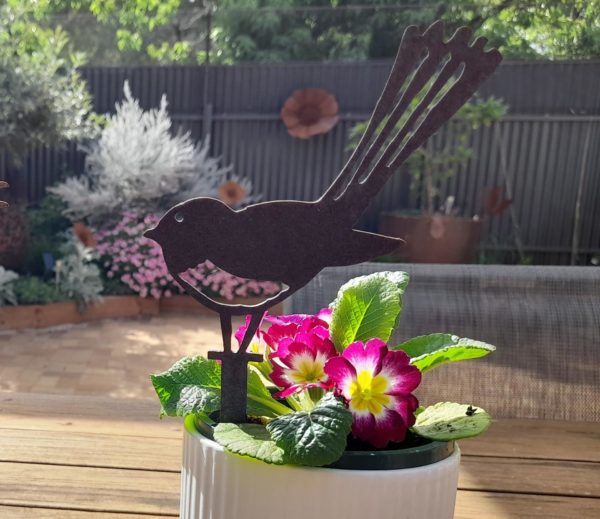 Wagtail Pot Decoration in Garden: The Wagtail Pot Decoration stands gracefully in a vibrant flower pot, showcasing its exquisite design and durable Corten steel finish, perfect for any outdoor setting.