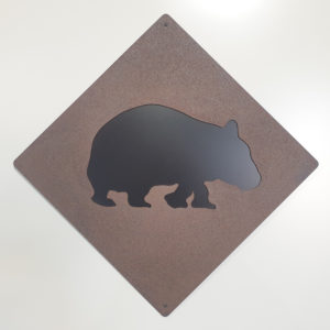 Wombat road sign made from 1.6mm thick Corten steel, rusted for a natural orange-red patina. The sign measures 63 cm square, featuring a black Colorbond background.